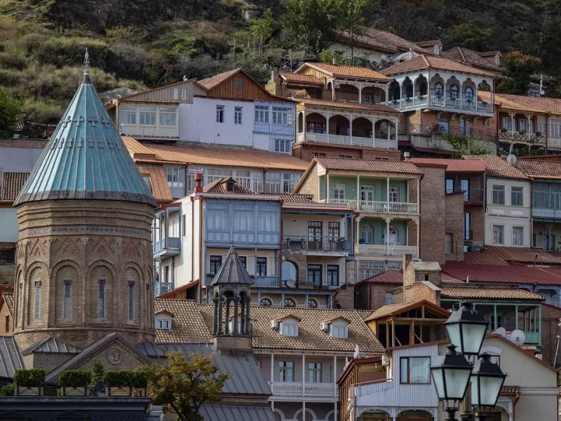 Old Tbilisi hillside — traditional houses with carved wooden balconies and a church dome